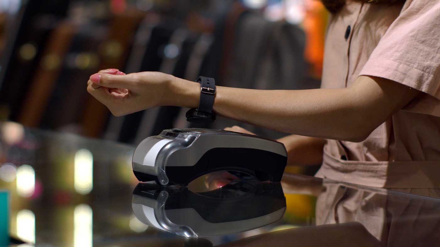 Woman using digital wallet and smart watch to pay at checkout