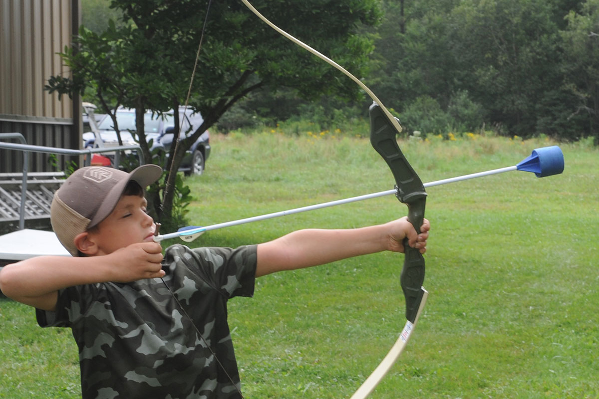 Child learning to shoot bow and arrow